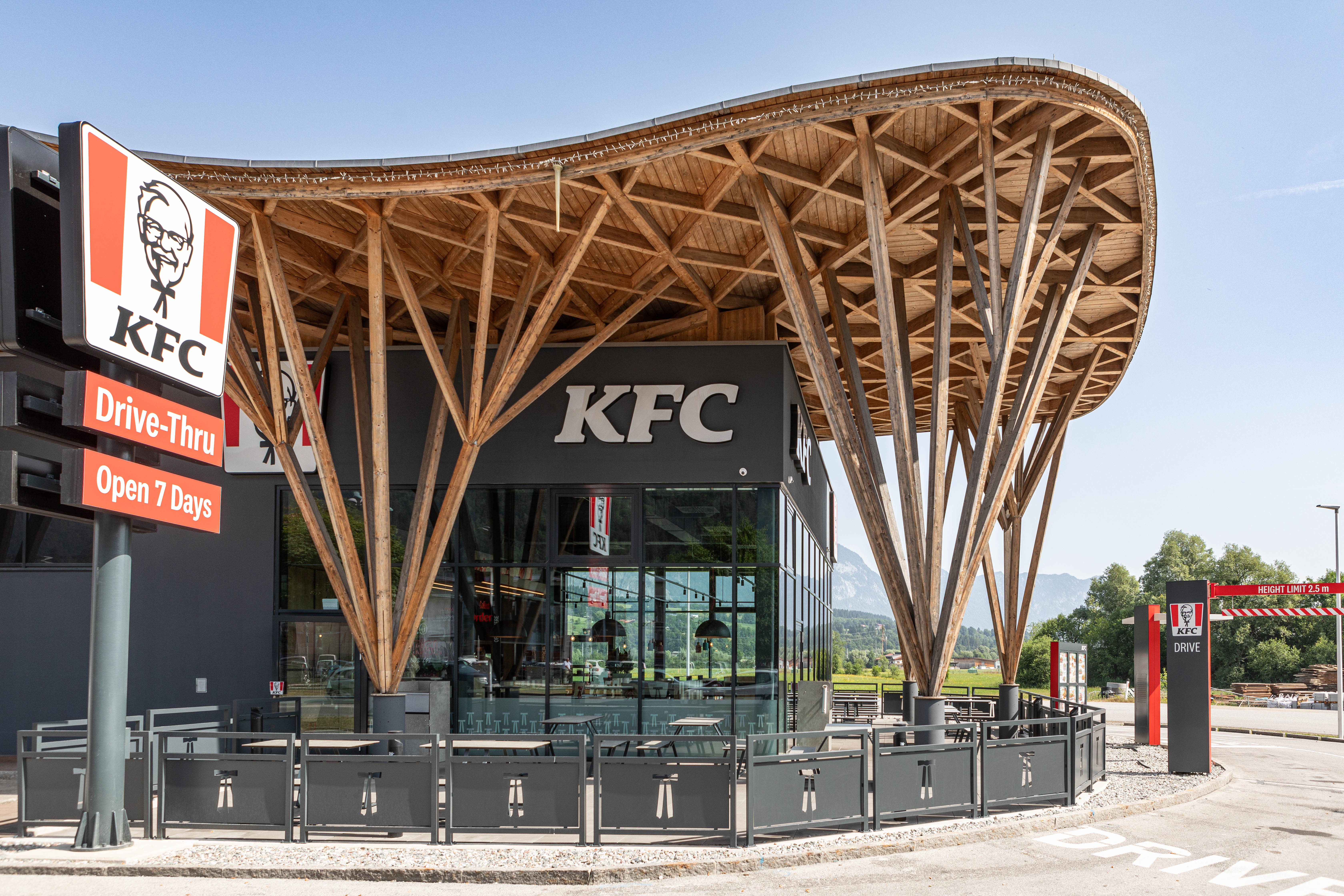KFC-Filiale Wörgl mit markantem Holz-Vordach und Drive-Thru-Schild