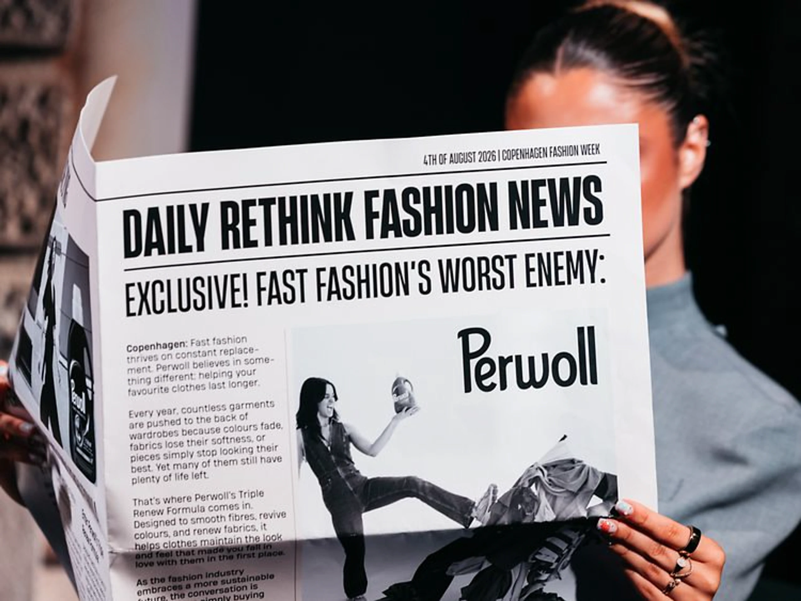 Frau liest eine Zeitung mit der Headline „Daily Rethink Fashion News“