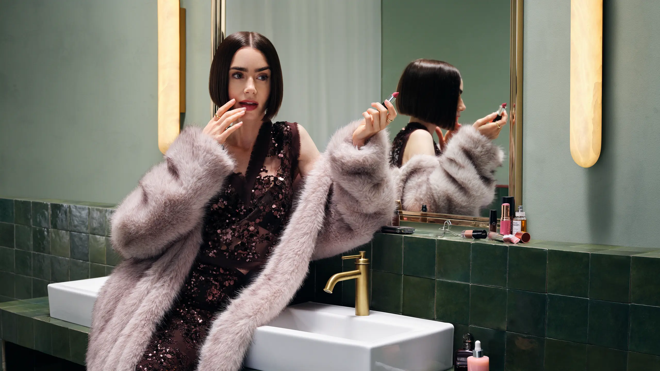 Lily Collins in Glitzerkleid und Fake Fur Mantel am Waschbecken