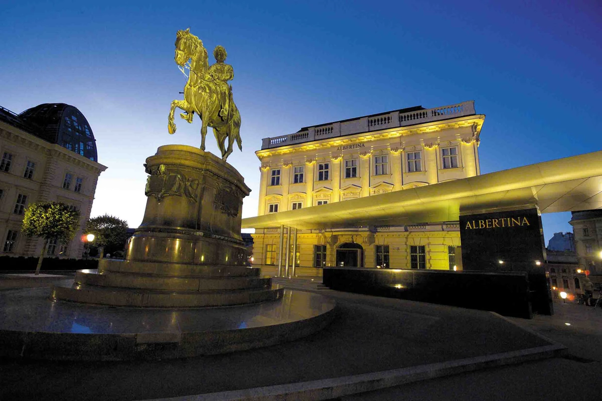 Erzherzog-Albrecht-Denkmal vor dem leuchtenden Albertina Museum in Wien bei Dämmerung.