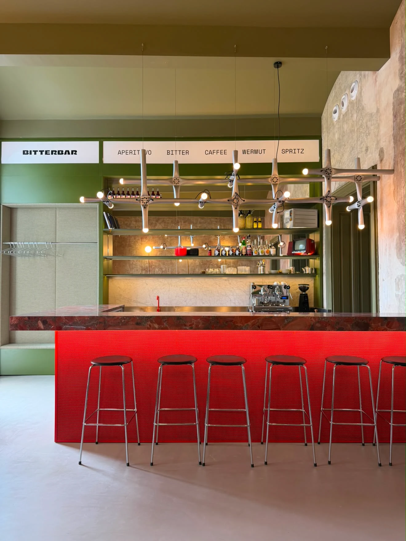 Moderne Bitterbar mit rotem Tresen, Barhockern und futuristischer Beleuchtung