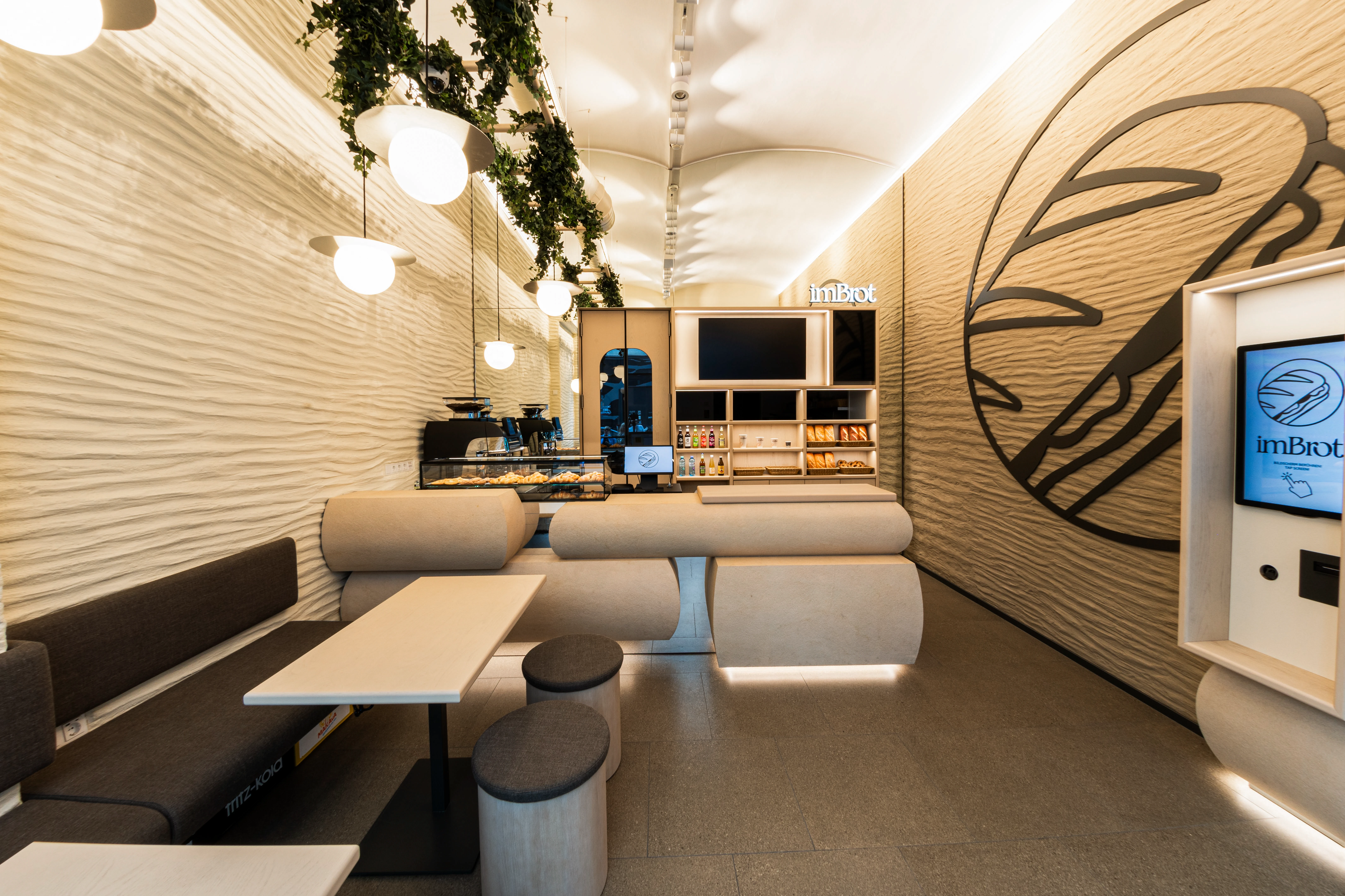 Moderne Bäckerei und Café mit stylischer Inneneinrichtung, Tresen, Sitzbereich und dekorativer Wandgestaltung