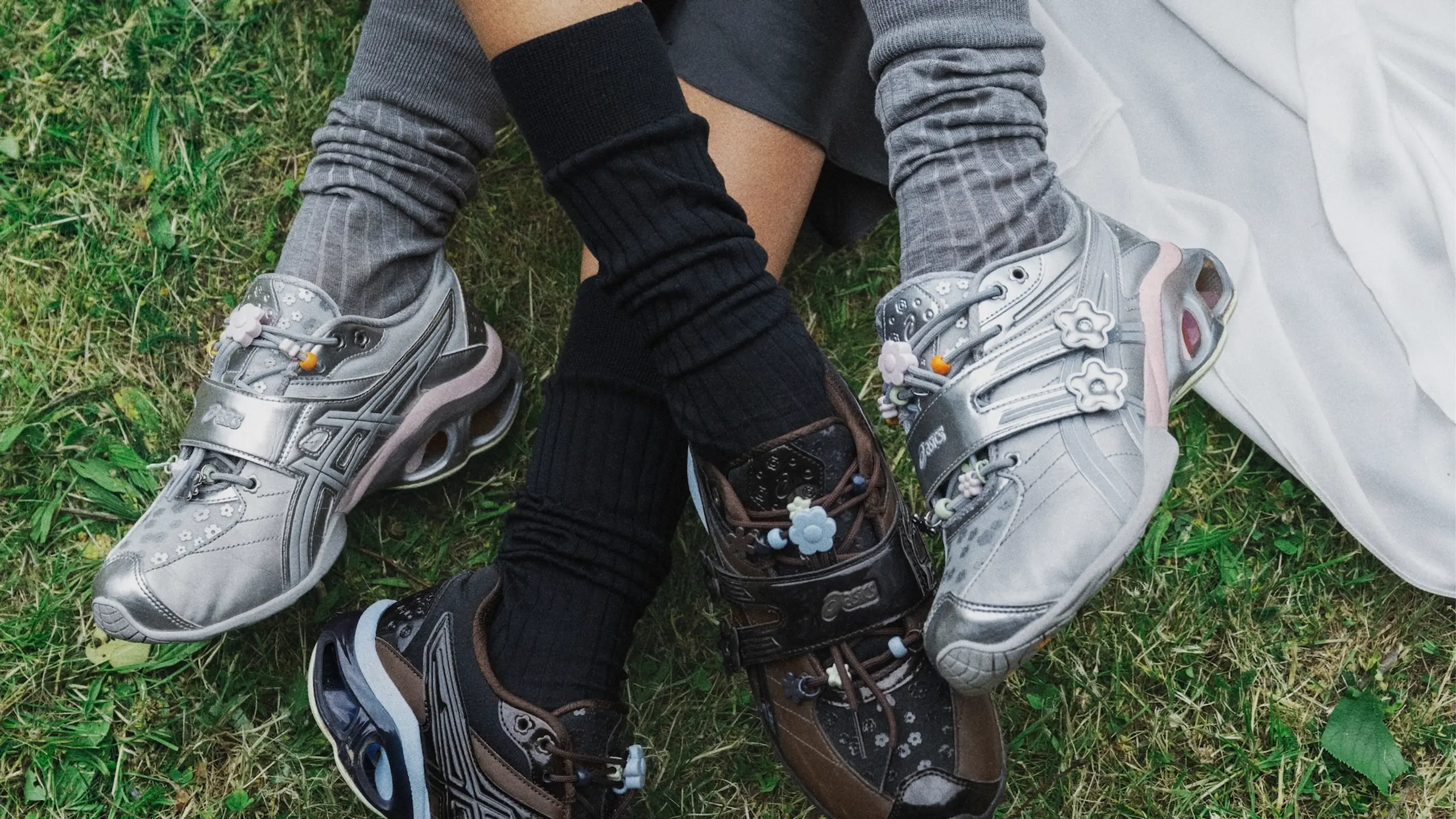 Close-up von zwei Frauen aus einer Wiese mit den Schuhen, hohen Tennissocken und langen Röcken