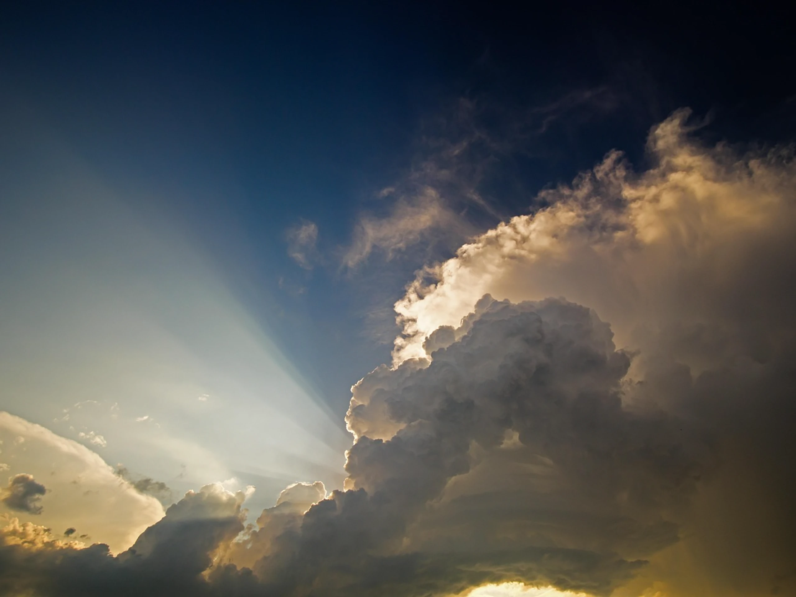 Gewitterwolken mit Sonnenstrahlen über einer Landschaft