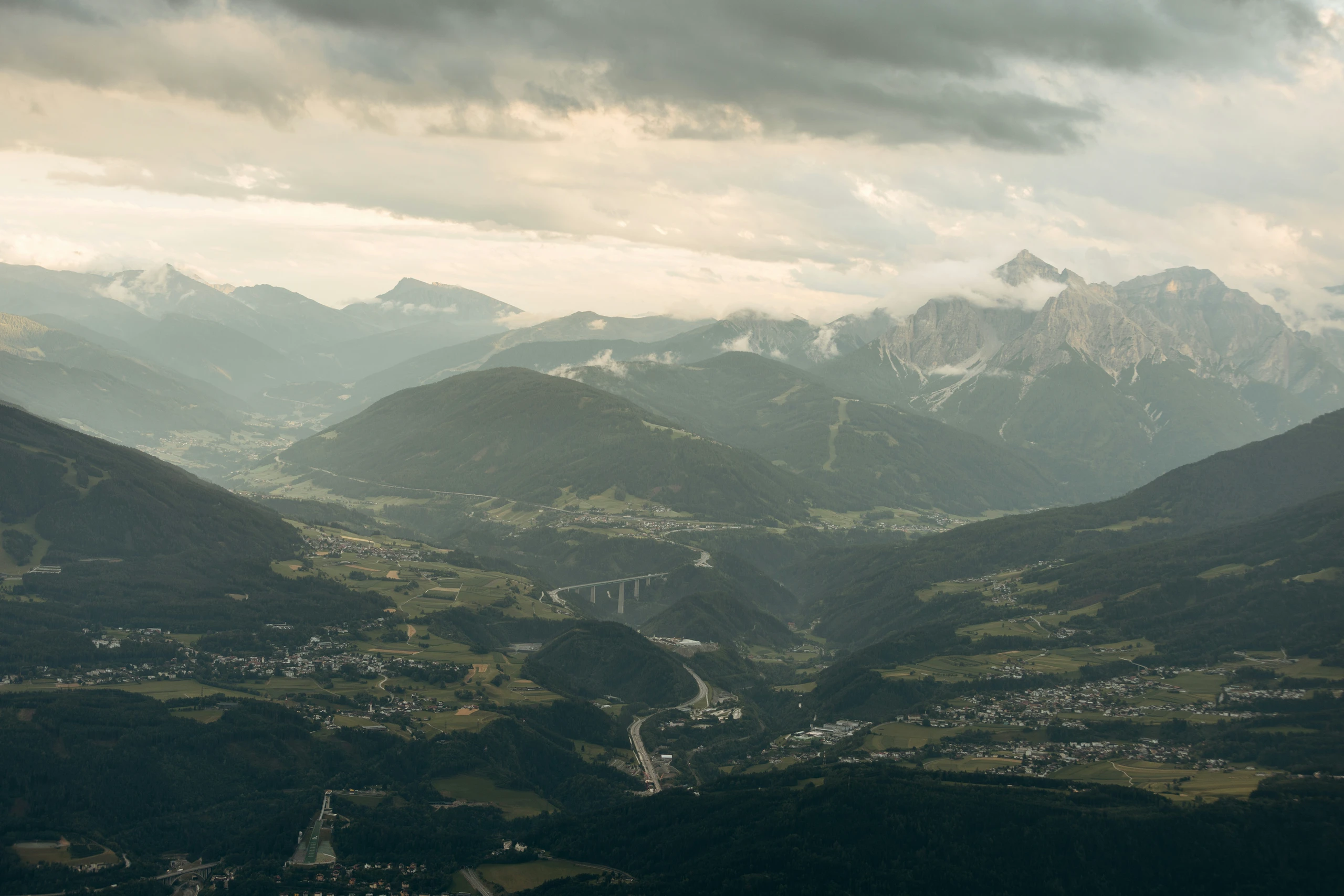 Autobahn im Inntal bei Innsbruck zwischen Bergen unter wolkigem Himmel