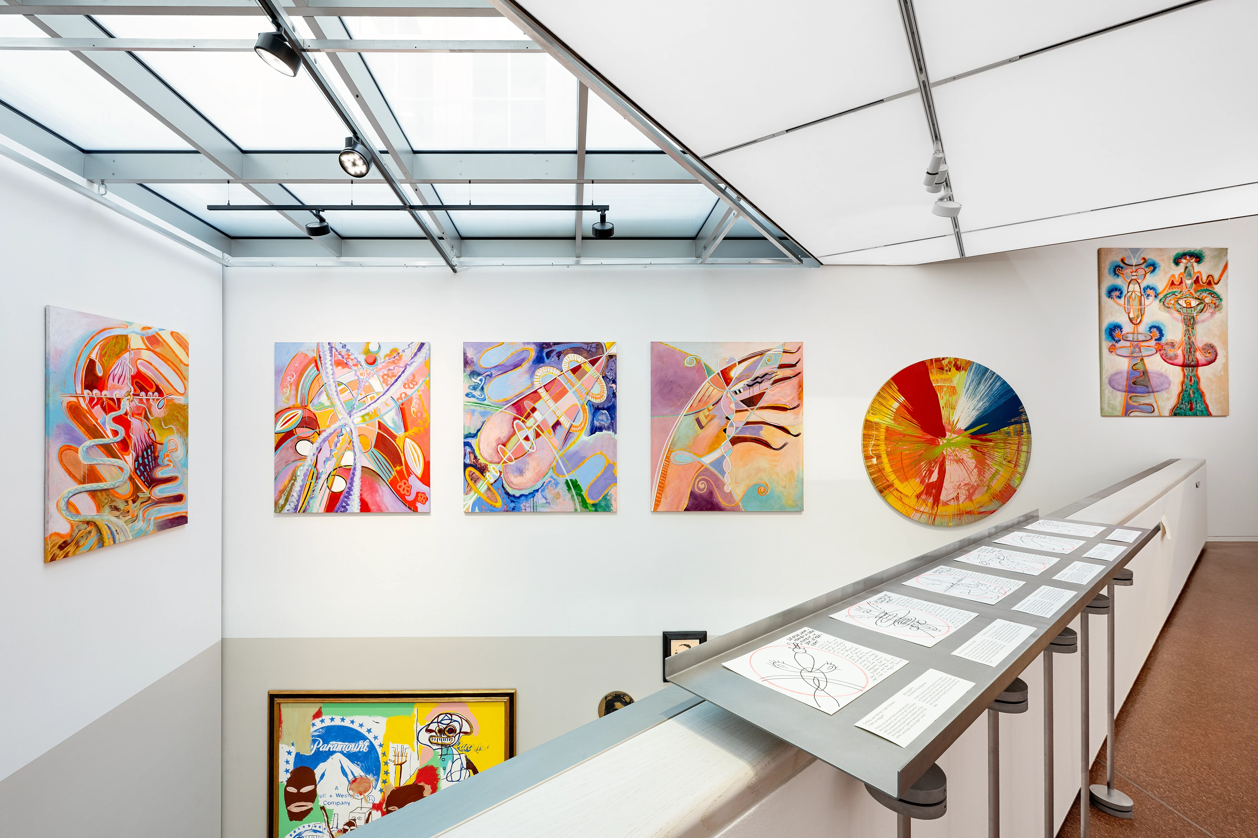 Ausstellung moderner und abstrakter Gemälde in einer hellen Kunstgalerie mit Oberlicht