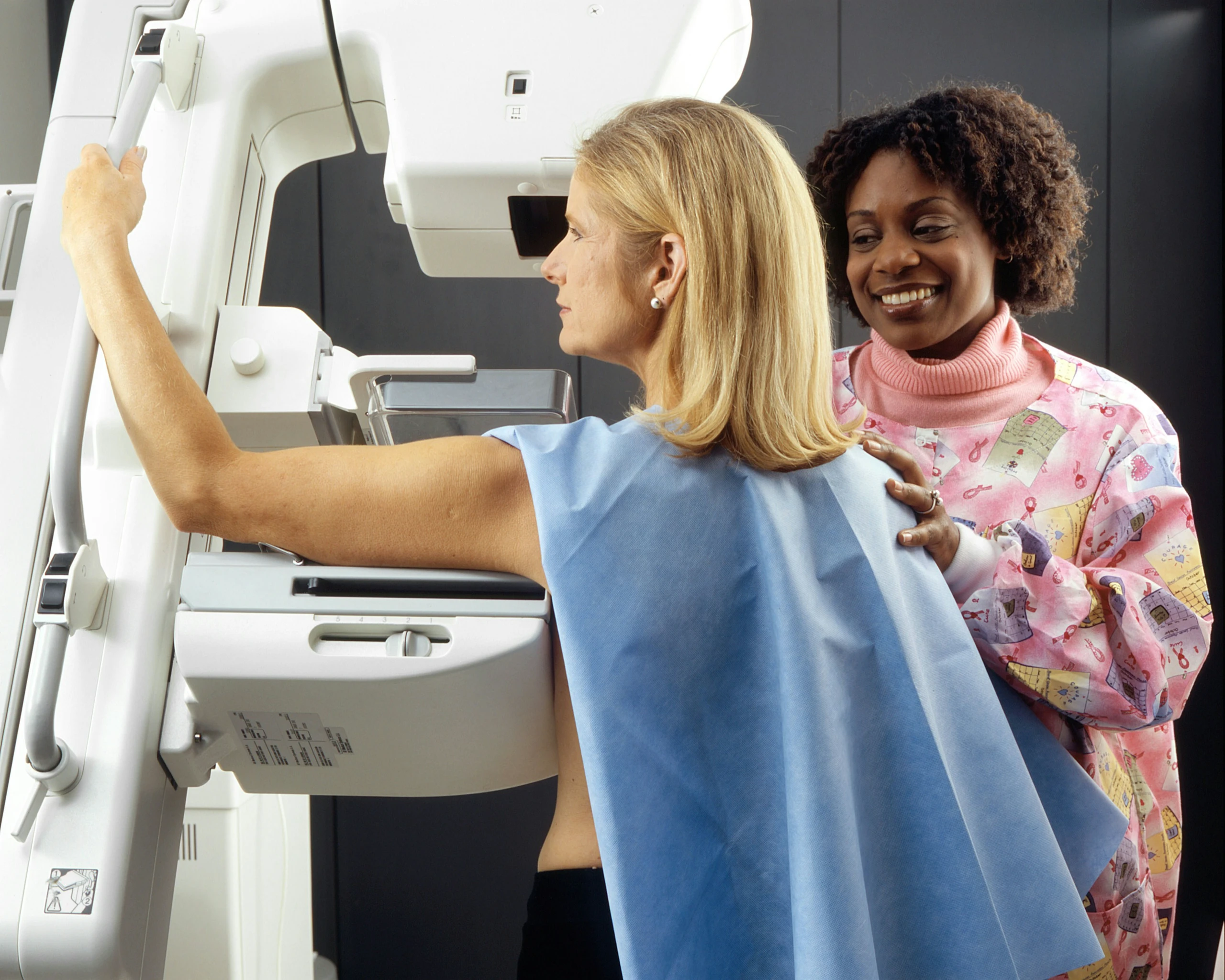 Eine Radiologietechnologin bereitet eine Patientin auf die Mammografie vor