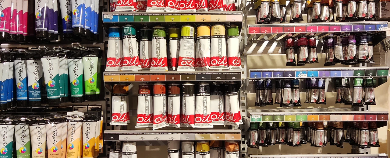 Farbauswahl im Kunstgeschäft: Acryl- und Ölfarben in Tuben, sortiert nach Farbe.