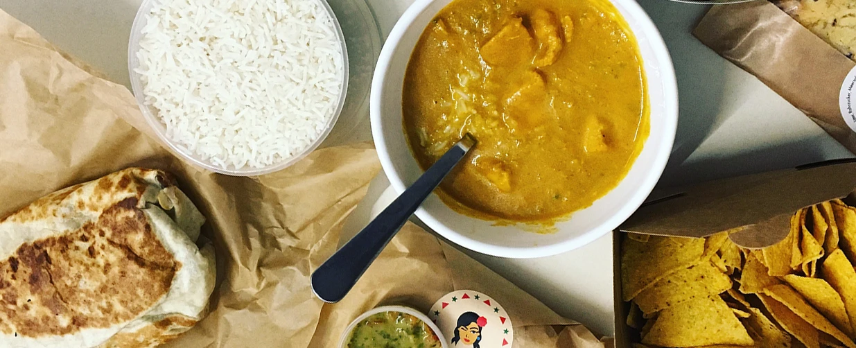 Reis, Burrito, Curry, Tortilla-Chips & Salsa. Leckeres Essen zum Mitnehmen.