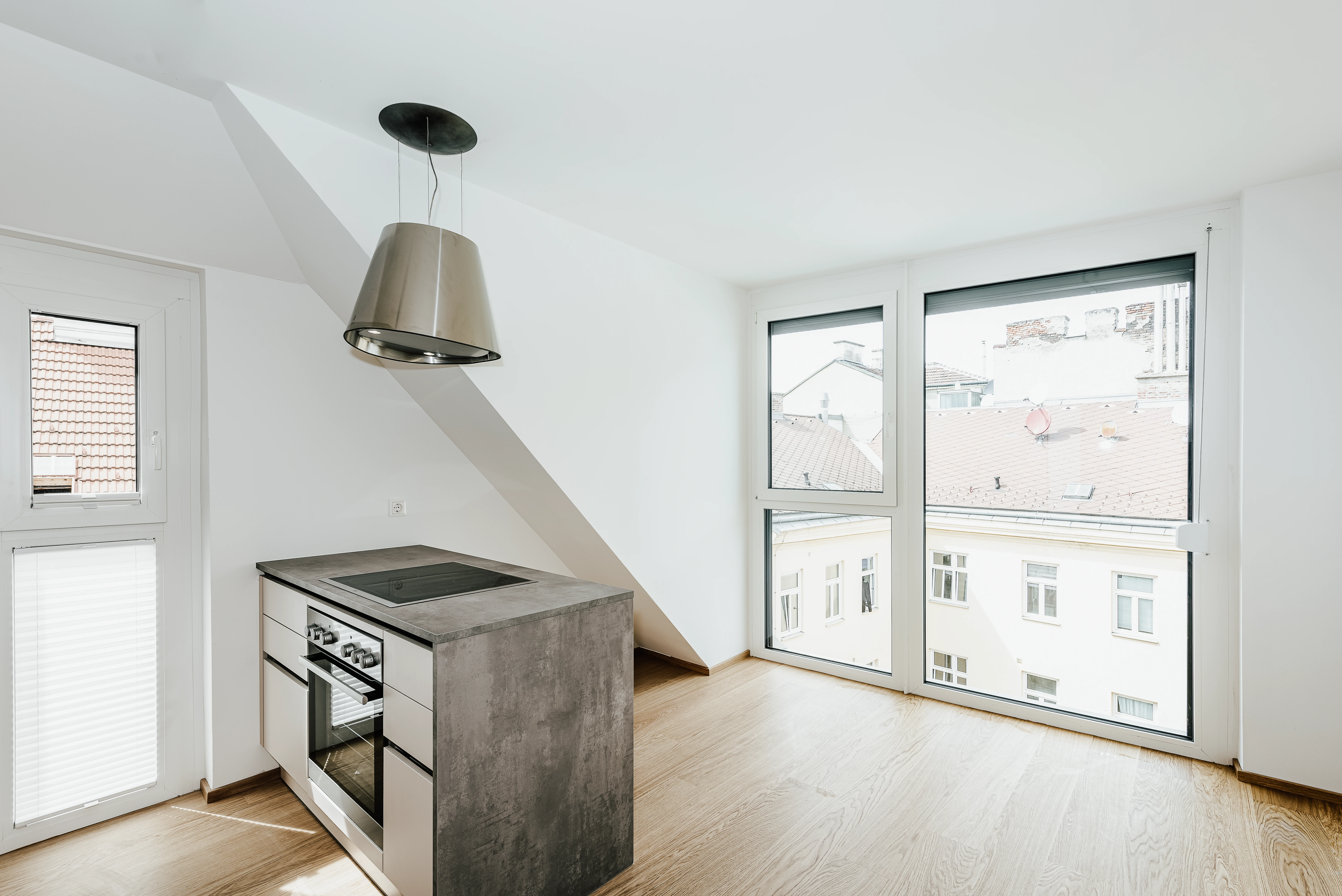 Küche in Dachgeschosswohnung mit dunkelgrauen Marmorplatten und Fensterfront