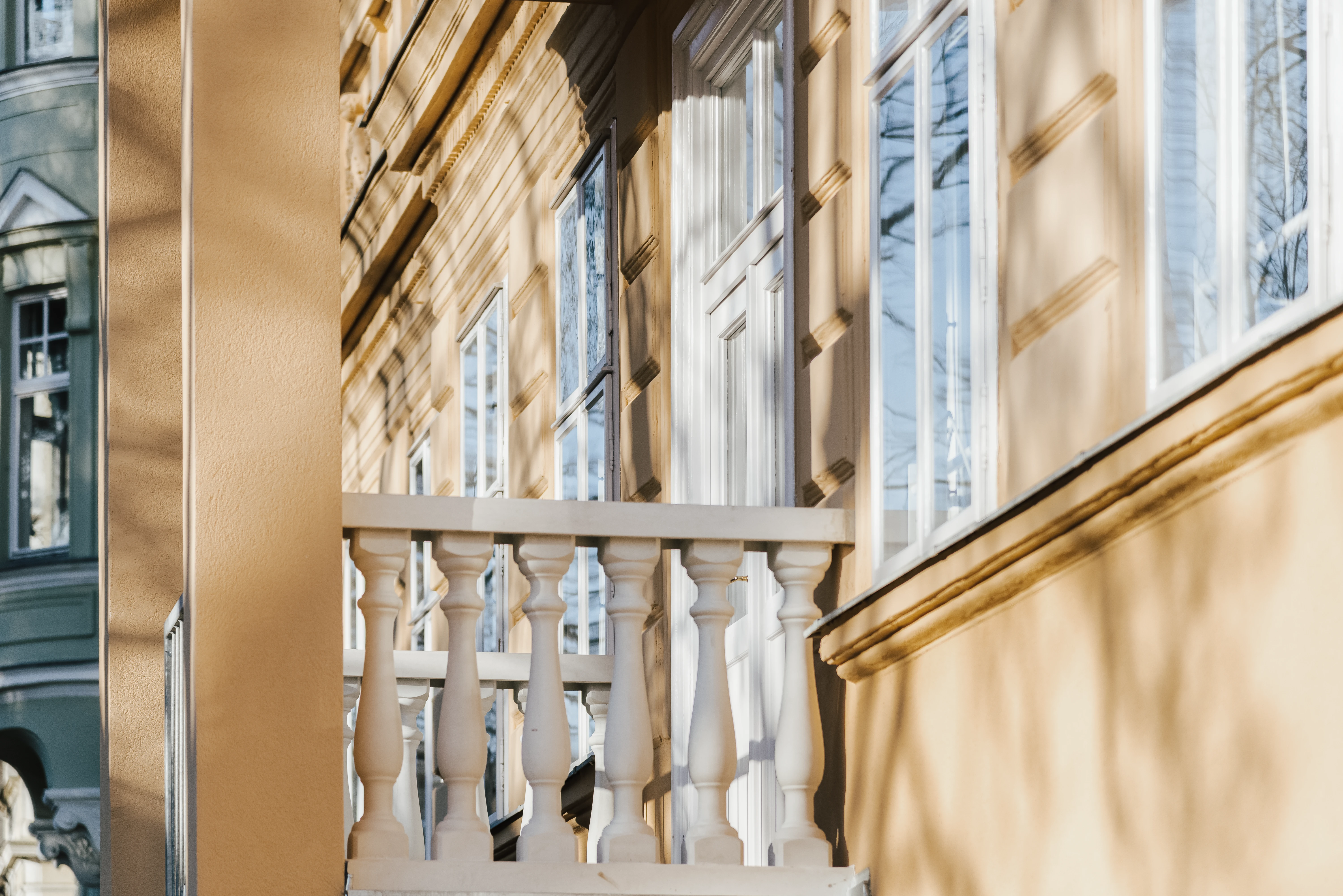 Gelbe Fassade mit kleinem Balustraden Balkon
