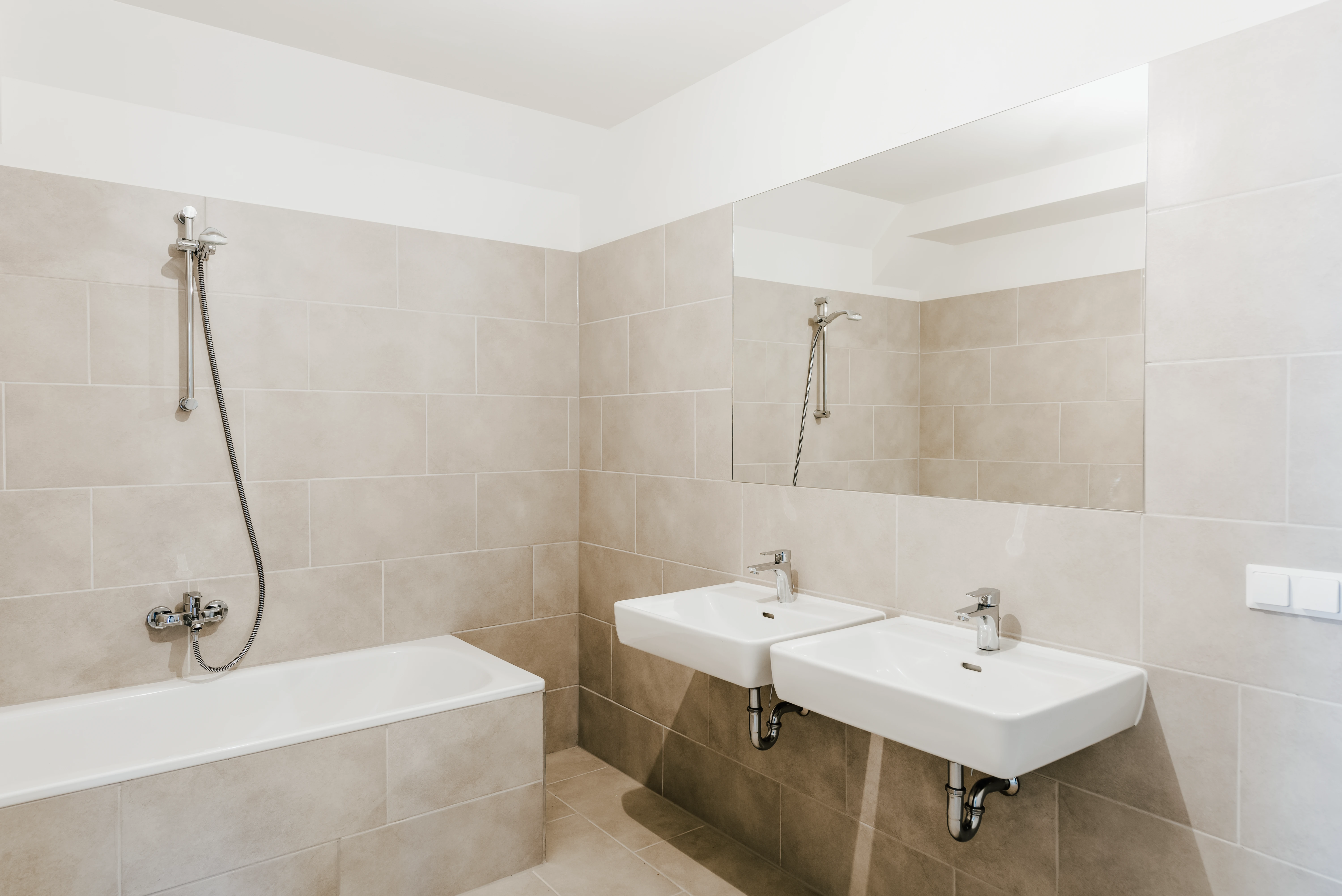 Modernes Badezimmer mit Badewanne und beigen Fliesen