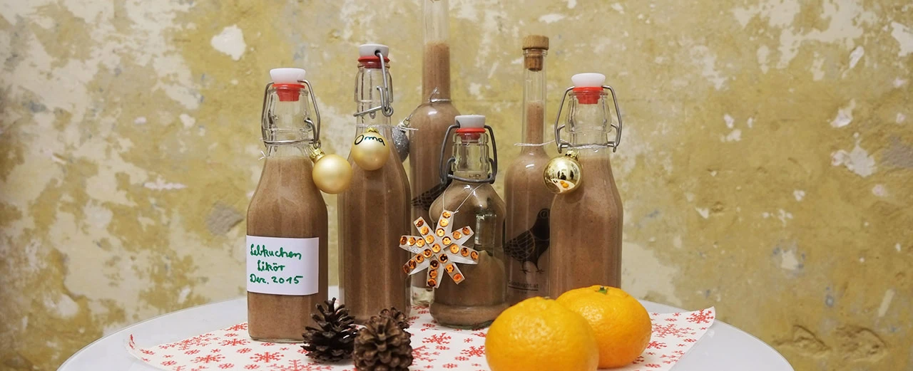 Selbstgemachter Lebkuchenlikör in Flaschen mit weihnachtlicher Dekoration. Perfekt für die Weihnachtszeit!