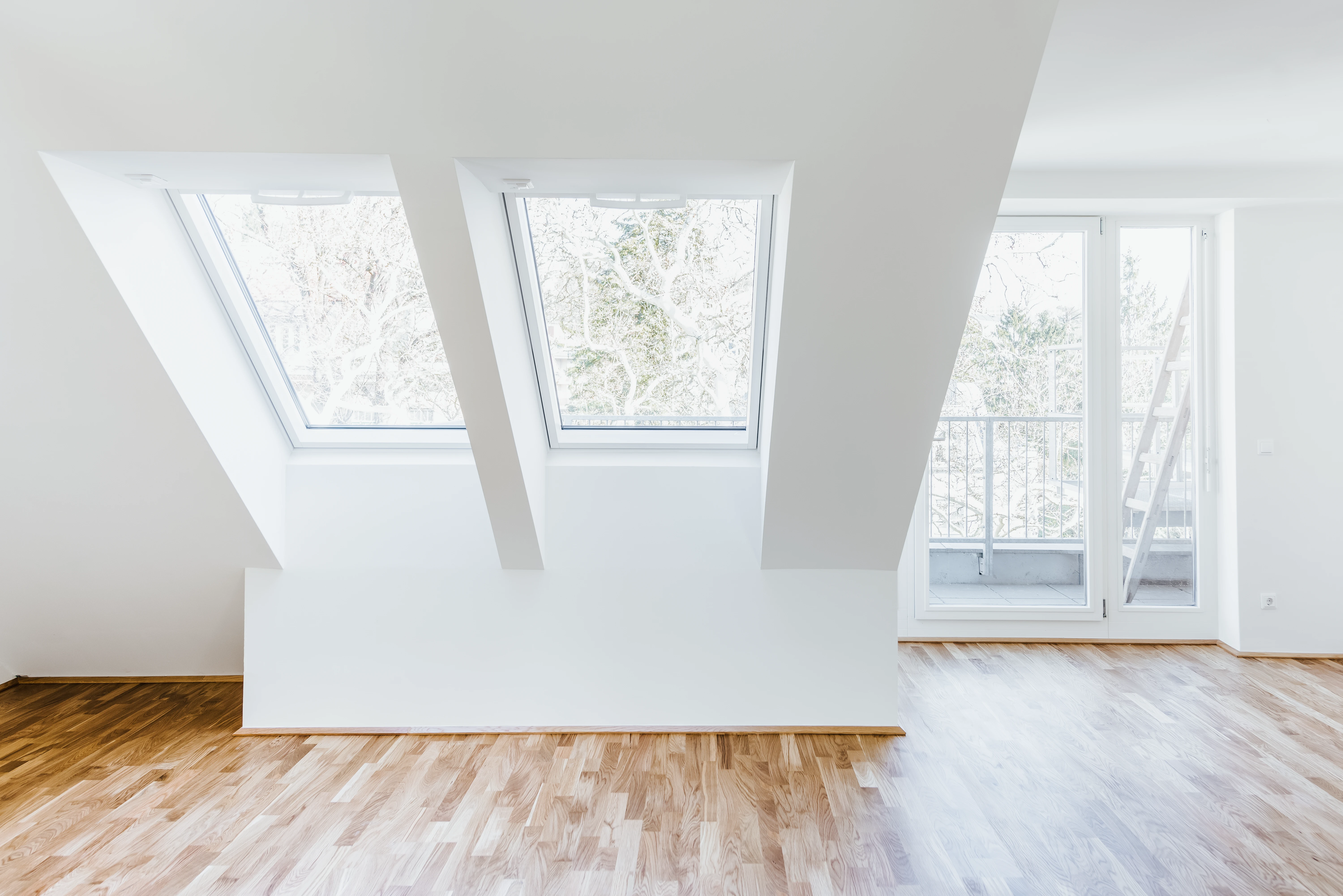 Dachgeschoss Wohninvestment mit Dachschrägen Fenstern und Sicht auf Balkon
