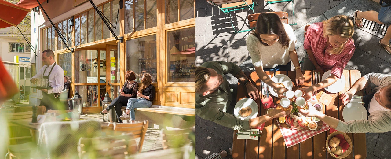 © Gustl kocht Freunde genießen Essen und Getränke auf der Terrasse eines Restaurants an einem sonnigen Tag.