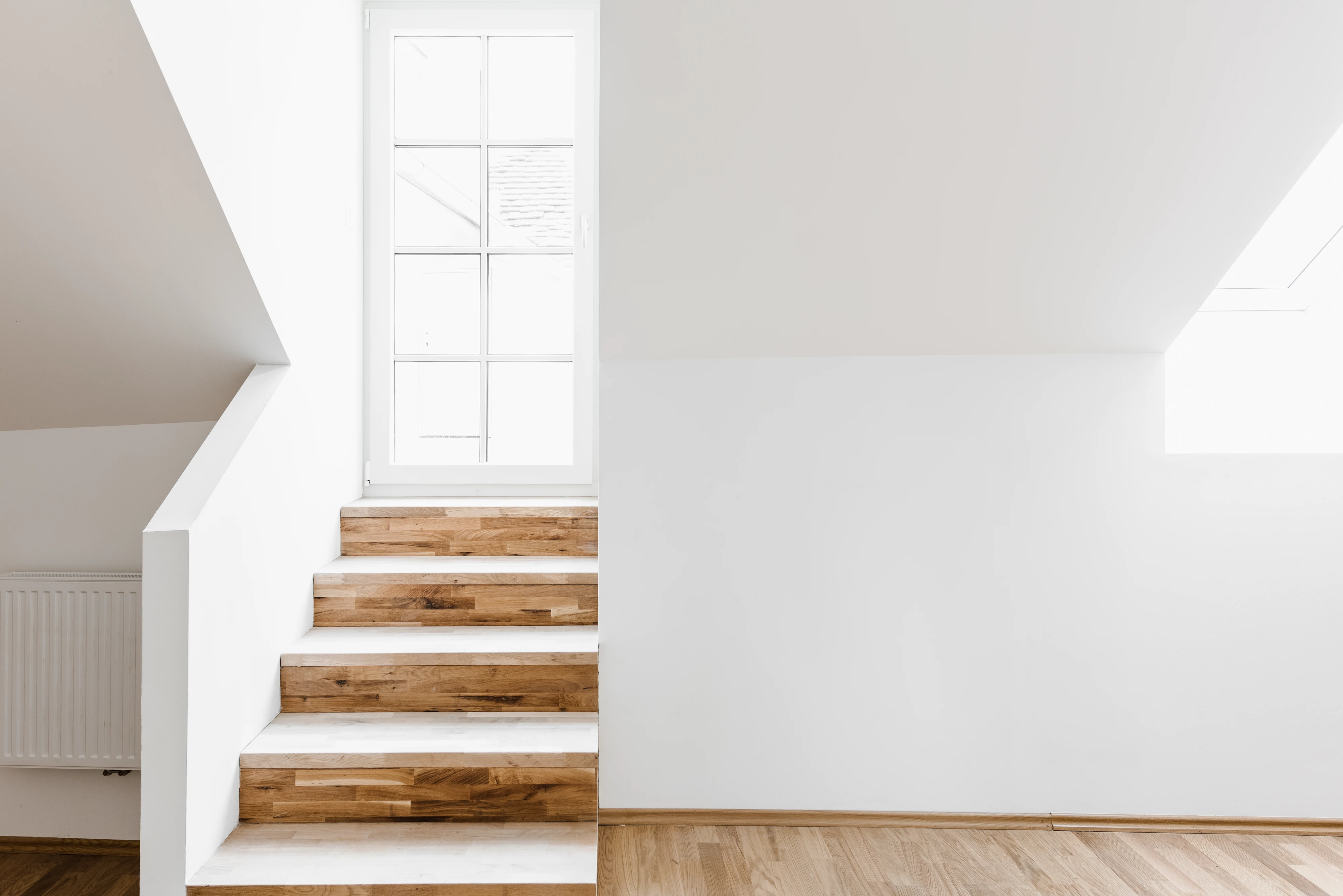 Weiße Wände und Holzstiege zu Terrasse in schöner Vorsorgewohnung