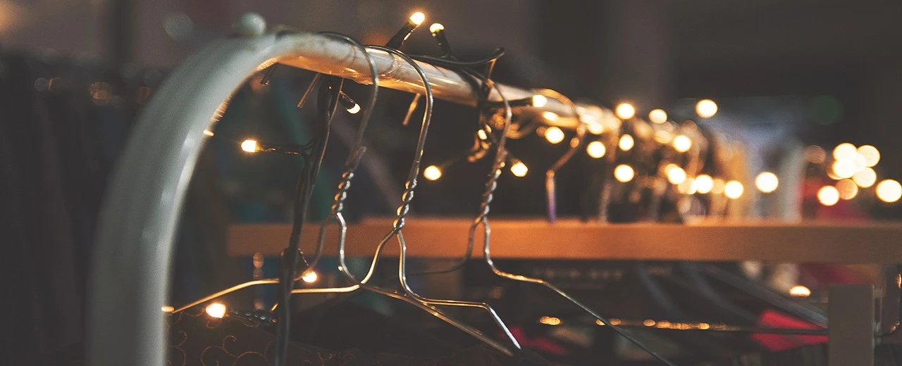 © Gianandrea Villa via Unsplash Kleiderbügel mit Lichterkette, warme, gemütliche Atmosphäre, weihnachtliche Dekoration.