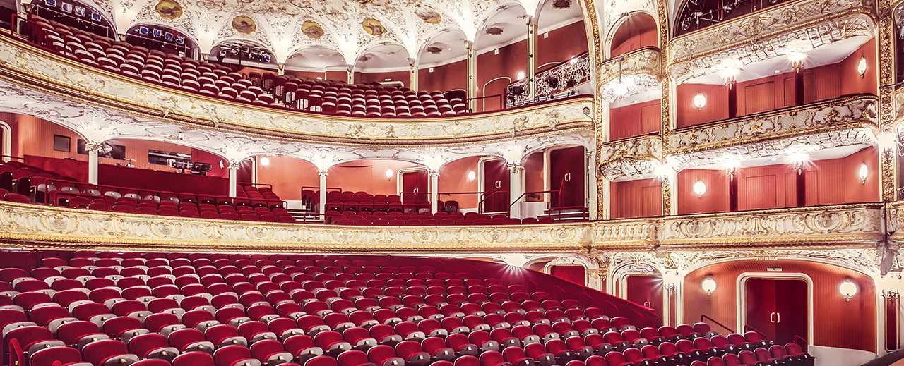 Bild eines prächtigen Theatersaals mit roten Samtsitzen und vergoldeten Verzierungen, erstellt mit Adobe Photoshop CS6.