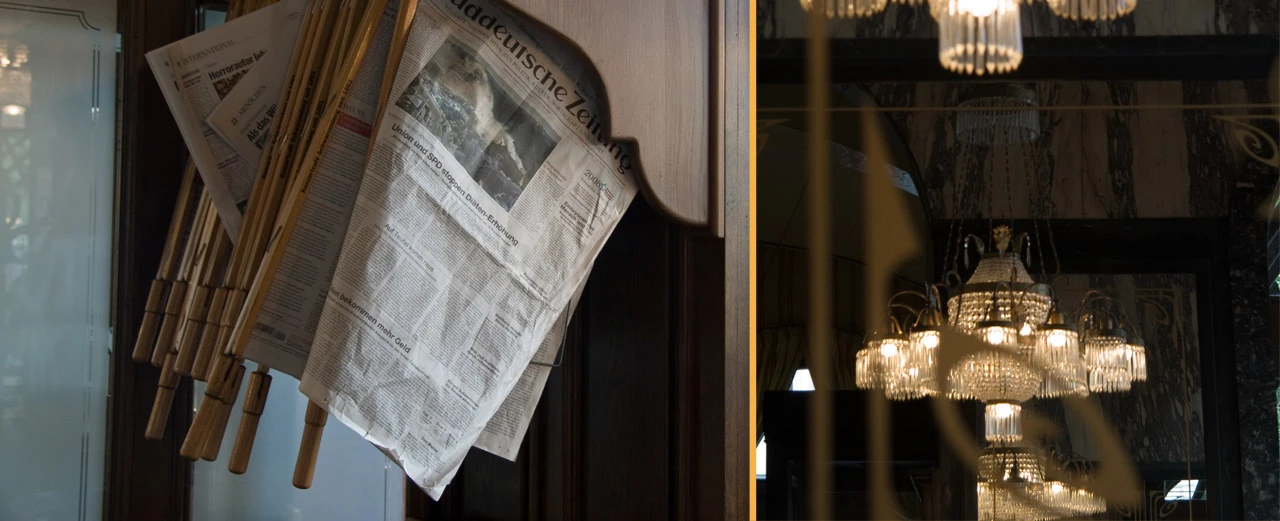 Zeitungen an einem Holzständer in einem Raum mit Kristall-Kronleuchtern. Erstellt mit Adobe Photoshop CC 2015 (Windows).
