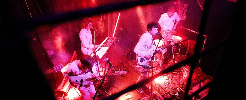 Indie-Band spielt live auf der Bühne. Rot beleuchtete Konzertatmosphäre. GIMP 2.10.6