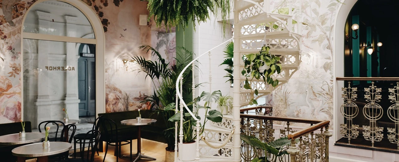 © The Long Hall Stilvolles Café mit Wendeltreppe und Pflanzendekoration. VSCO Filter, A6 Preset. Copyright 2020.