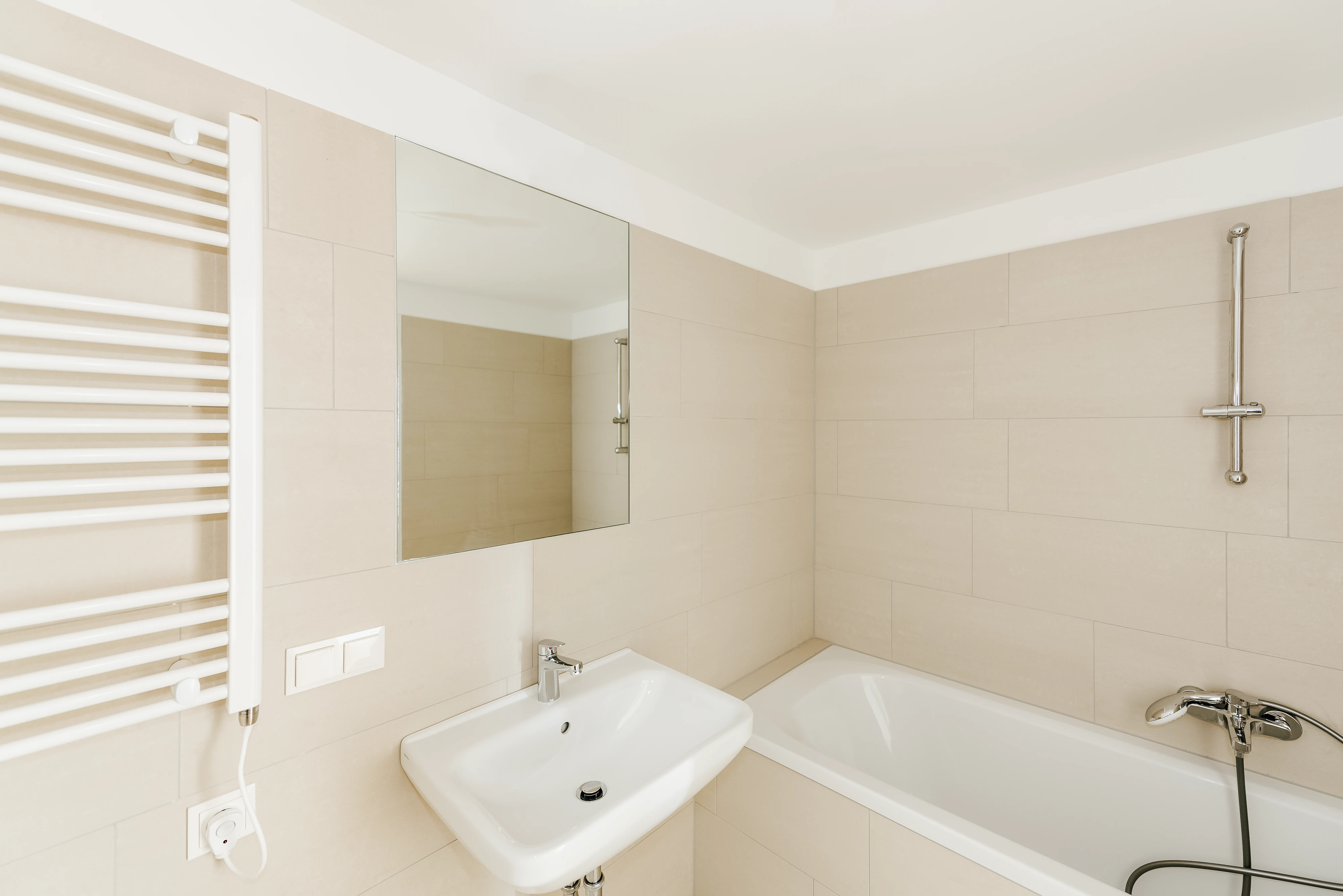 Modernes Badezimmer mit Badewanne und beigen Fliesen