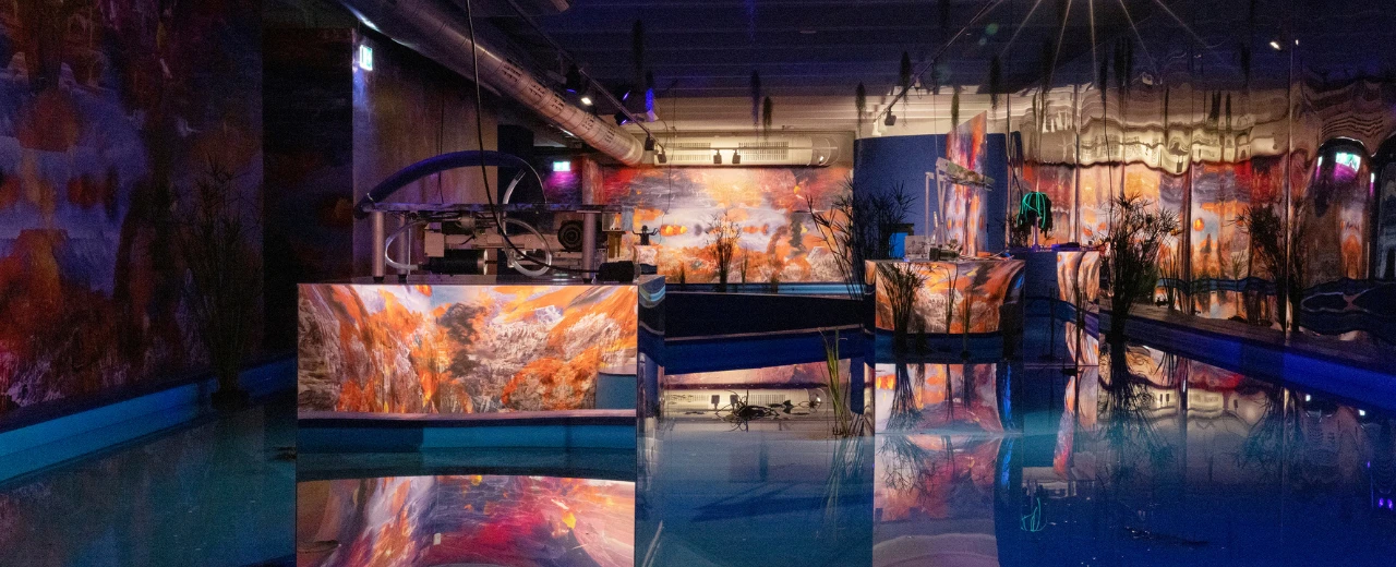 Surreale Kunstinstallation im Kunthaus: Wasserbecken mit Projektionen von Landschaften und technischen Elementen. Modernes, abstraktes Design.