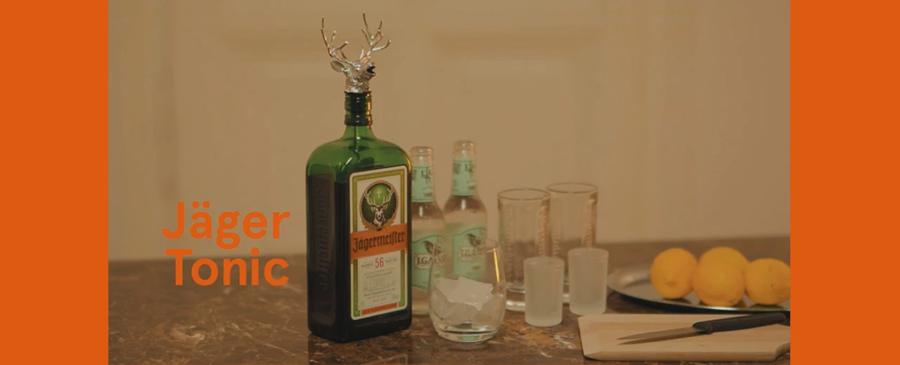 Jägermeister Tonic Rezept: Zutaten wie Jägermeister Flasche, Tonic, Eis, Zitronen und Gläser.