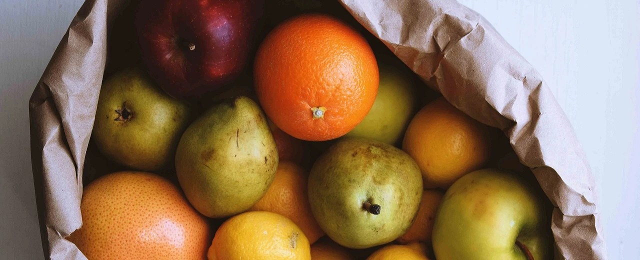 Braune Papiertüte mit Äpfeln, Birnen, Orangen & Grapefruits.